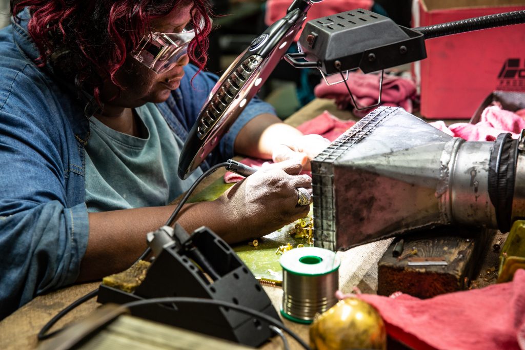 Copyrighted 2018 Ken Cooper Woman holds electrical tool in her hands while working at Helwig Carbon