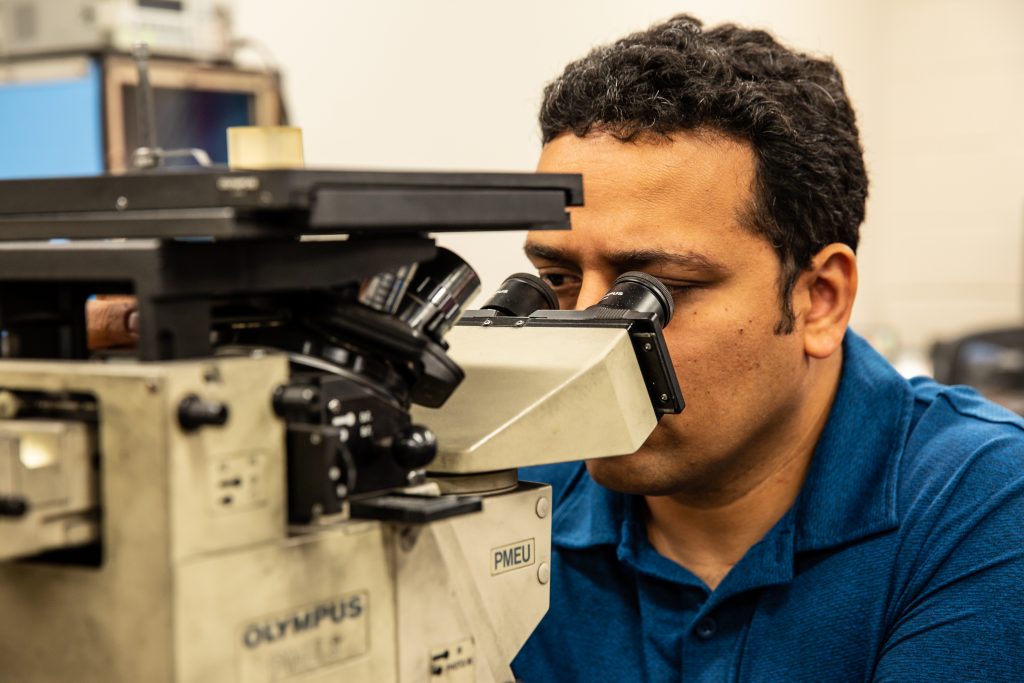 Copyrighted 2018 Ken Cooper man looking through microscope at Helwig Carbon